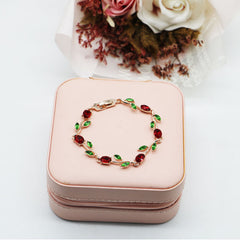 Elegant Rose Gold Bracelet With Red Crystals And Green Leaves
